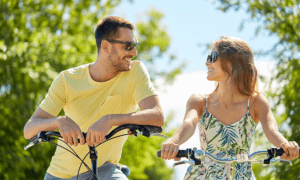 Dating | people, leisure and lifestyle concept - happy young couple with bicycles at country